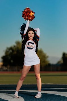 a woman in a cheerleader uniform holding a pom - pom on top of her head