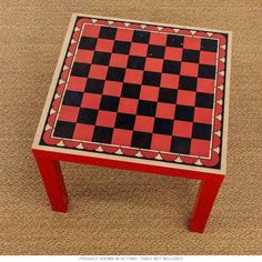 a red and black checkerboard table on carpeted area with beige flooring