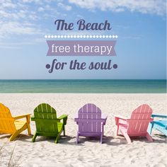 four colorful lawn chairs sitting on top of a sandy beach