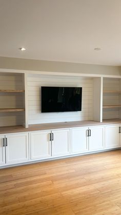 a living room with white cabinets and a flat screen tv