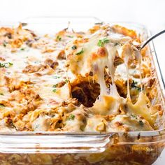 a casserole dish with meat and cheese being lifted from the casserole