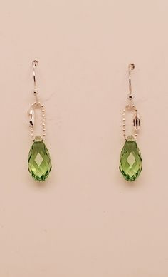 Peridot briolette drop earrings are pale green Swarovski crystals that dangle from shiny delicate silver tone ball chain and matching ball end ear wires. Created and designed by TLP from Takeen Arts. Item E411. Nickel-free Green Crystal Earrings In Sterling Silver, Nickel-free Green Sterling Silver Crystal Earrings, Green Sterling Silver Crystal Earrings, Green Teardrop Crystal Earrings Pierced, Green Teardrop Crystal Earrings, Green Crystal Teardrop Earrings, Green Briolette Earrings For Pierced Ears, Silver Briolette Crystal Earrings With Ear Wire, Sterling Silver Briolette Earrings For Party