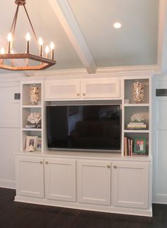 a large entertainment center with built in cabinets