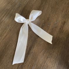 a white ribbon tied on top of a wooden table