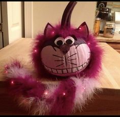 a pink stuffed animal with lights on it's head and tail sitting on top of a wooden table