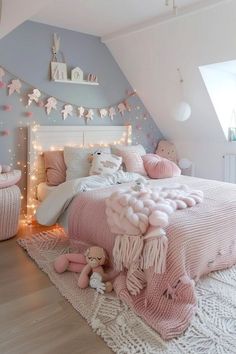 a bedroom decorated in pink and white with lights on the ceiling, rugs and bedding