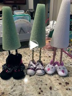 three pairs of shoes are lined up in front of two tall trees on the counter