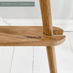 a close up of a wooden chair with the word din osaur on it