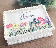 a decorated cake with flowers and words on it