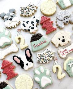 many decorated cookies are laying on the table together, including dogs and fire hydrants