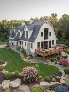 an aerial view of a large white house with lots of windows and landscaping around it