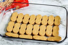 cookies in a glass baking dish next to a bag of crackers and a packet of peanut butter