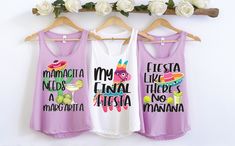 three tank tops hanging on a rack with flowers