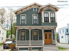 a two story house with porches on the front and second floor, painted blue