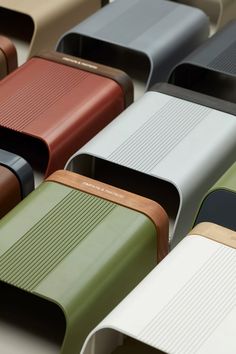 many different colored leather cases sitting on top of each other, all lined up together