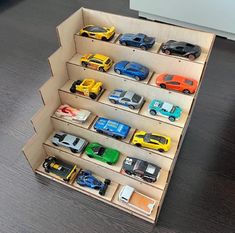 there are many toy cars on display in the cardboard box that is open to show them