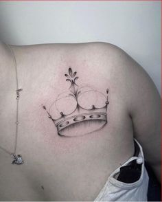 a woman's chest with a crown tattoo on her left side ribcage