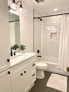 a white bathroom with black and white accessories