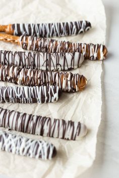 chocolate covered pretzels are lined up on wax paper and drizzled with icing