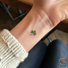 a small four leaf clover tattoo on the wrist