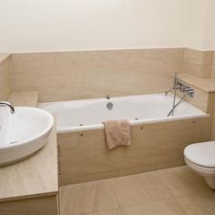 a white toilet sitting next to a bath tub