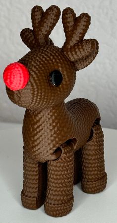 a brown knitted reindeer with red eyes