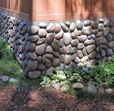 a rock wall in front of a house