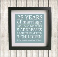 the 25 years of marriage is displayed in a black frame on a wooden paneled wall