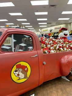 an old red truck with stuffed animals in the back