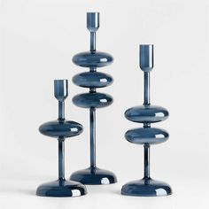 three tall blue candlesticks sitting next to each other