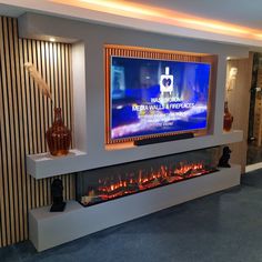 a large television mounted to the side of a wall with a fire place in front of it