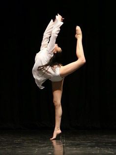 a woman doing a handstand on a stage