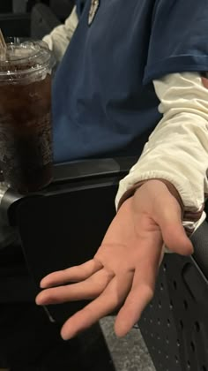 a person sitting at a table with their hand out