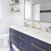 a white and blue bathroom with gold handles