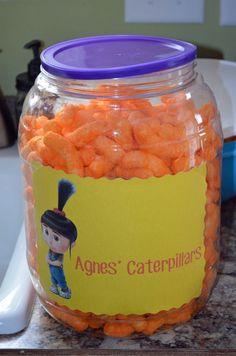 a jar filled with orange candies sitting on top of a counter