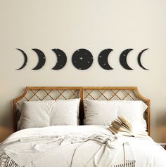 a bed with four phases of the moon mounted on it's wall above it