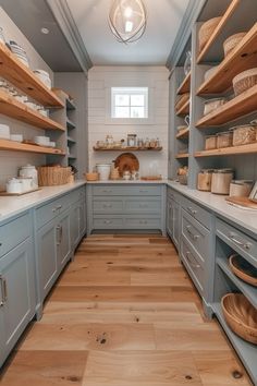 a kitchen with gray cabinets and wood floors is pictured in this image, there are baskets on the shelves