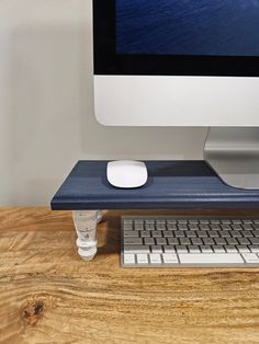 a computer monitor sitting on top of a wooden desk next to a keyboard and mouse