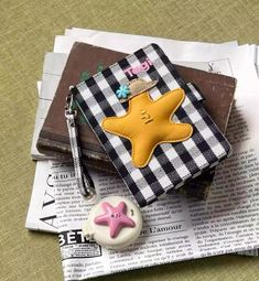 a wallet with a star on it sitting next to a button and keychain