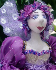 a close up of a doll wearing a purple dress