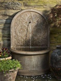 a water fountain surrounded by potted plants