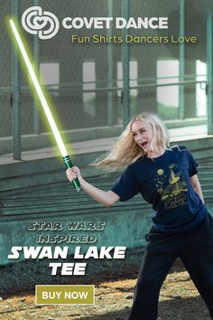 a woman holding a green light saber in her right hand and the words swan lake tee on it