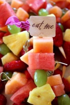 fruit skewers with a sign that says eat me