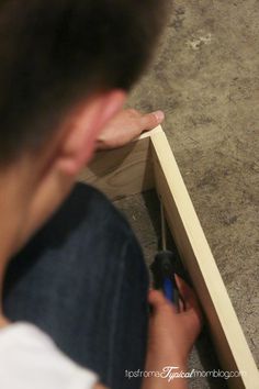 a man is using a screwdriver to fix a piece of wood