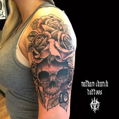 a woman with a skull and roses tattoo on her arm