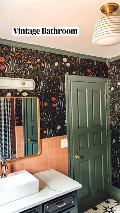 a bathroom with floral wallpaper and green doors