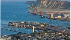 an aerial view of a harbor with boats in the water and large cranes on the shore