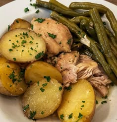 a white plate topped with potatoes and green beans