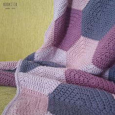 a crocheted blanket sitting on top of a couch