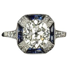 This vintage style diamond ring is impressive in size with a gorgeously detailed Art Deco style design! The true antique 2.47ct old mine cut center diamond is framed by rich blue French cut sapphires for a bold pop of color and contrast! Highlights: - True antique center diamond, cut around the turn of the 19th to 20th century - EGL-USA certification - Large 2.47ct size - Eye clean and nice white face up with grades of I-J SI1 - Natural sapphire accents with French cuts for added sparkle - Brigh Italian Art Deco, European Cut Diamond Ring, Blue Sapphire Diamond Ring, Detailed Art, Art Deco Diamond Rings, Modern Engagement Rings, Family Jewellery, Art Deco Engagement, Blue Sapphire Diamond